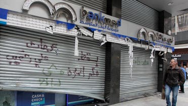 A man walks past a damaged bank in Beirut. (Reuters)