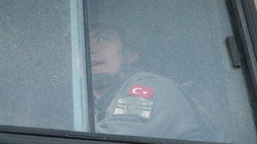 A Turkish military personnel looks out the window of a military vehicle as it enters the Bab al-Hawa crossing at the Syrian-Turkish border, in Idlib governorate, Syria. (Reuters)