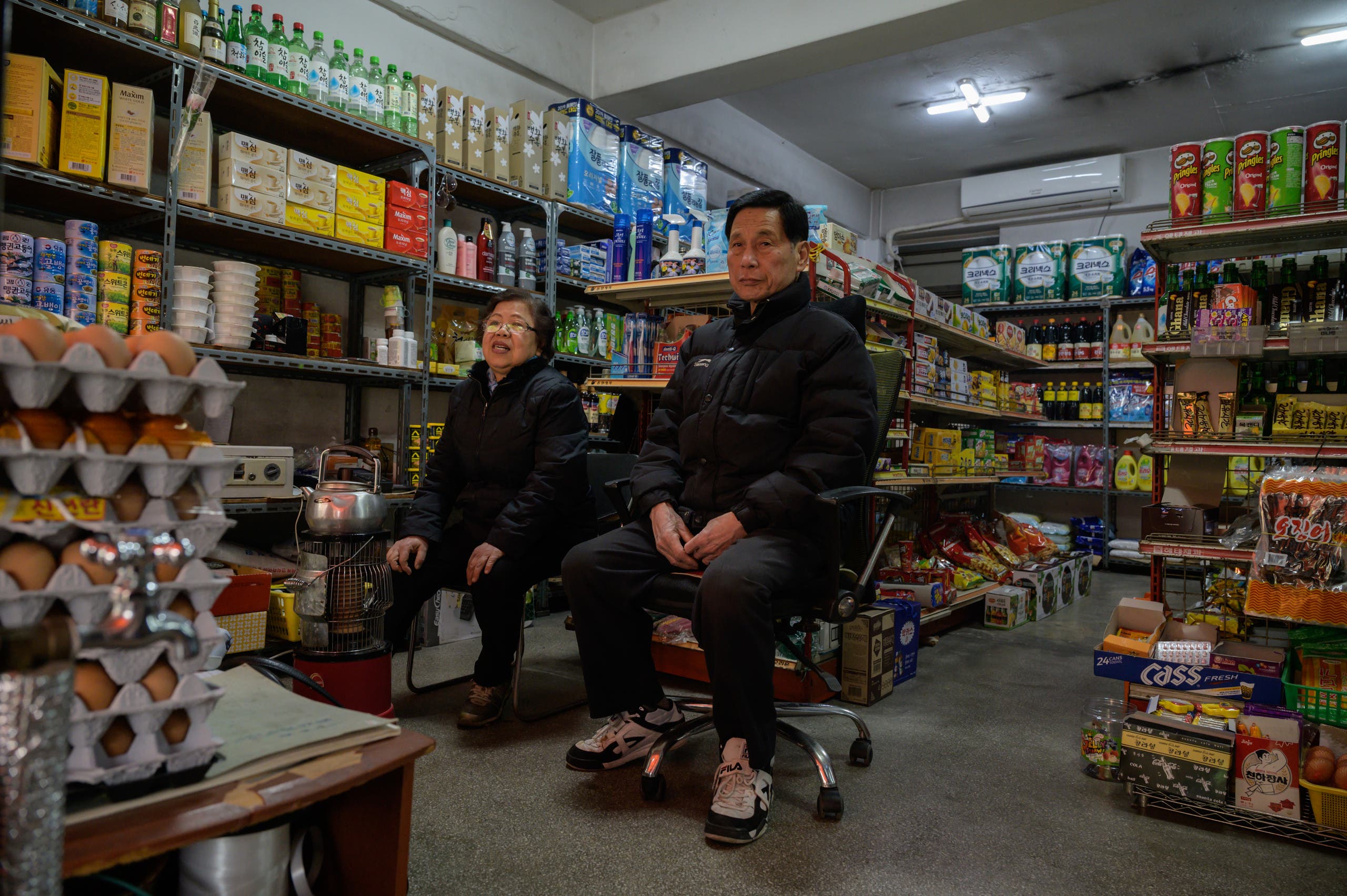 Owner Kim Kyung-soon (L) sits in the Pig Rice supermarket in Seoul on February 13, 2020. (AFP)