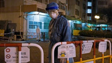 A personnel wearing protective suit waits near an entrance at the Cheung Hong Estate, a public housing estate during evacuation of residents in Hong Kong, Tuesday, Feb. 11, 2020. (AP)