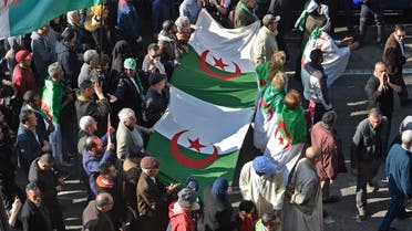 Algerians carry large national flags as they march in an anti-government demonstration in the capital Algiers on February 14, 2020. (AFP)