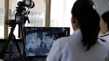 Airport personnel look at thermal scanners as they check on arriving passengers at Manila's international airport, Philippines, Thursday, Jan. 23, 2020.(AP)
