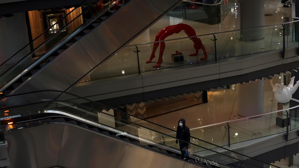 A man wearing a face mask rides an escalator inside a shopping mall, following an outbreak of the novel coronavirus, in Beijing, China February 12, 2020. (Reuters)