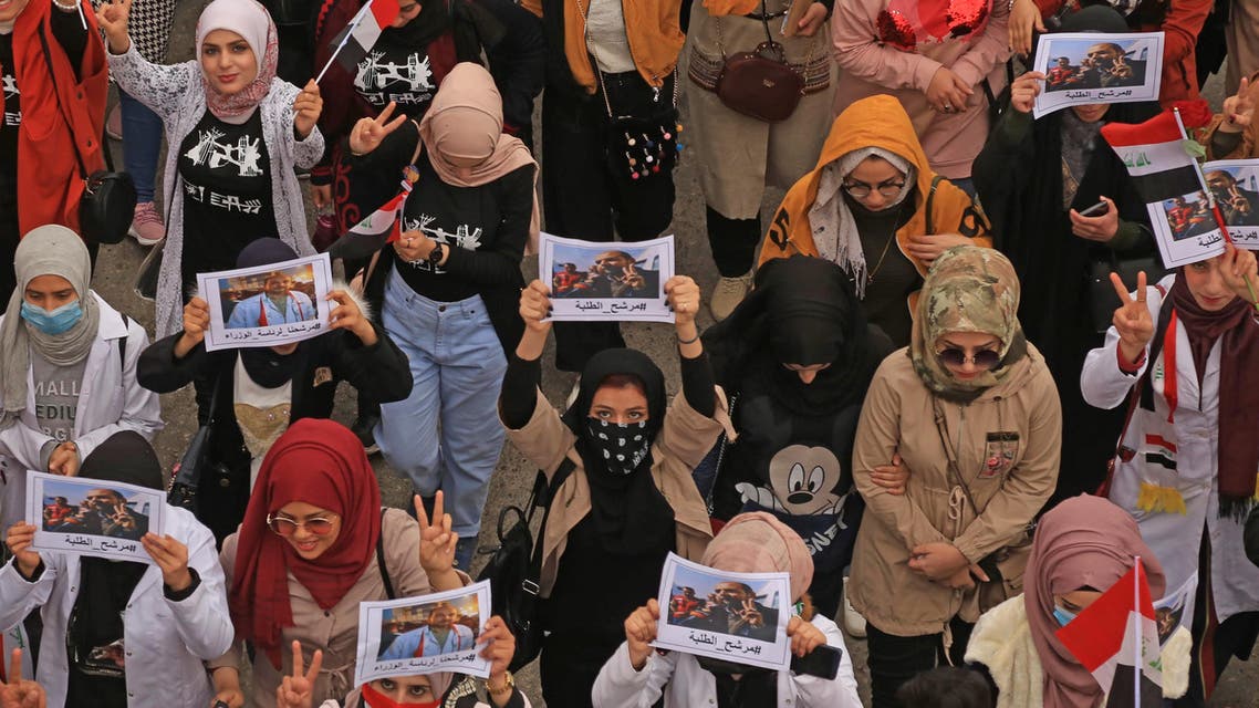 Iraqi women lift placards bearing the picture of Alaa al-Rikabi, a pharmacist who has become a prominent figure of the protest movement in Karbala, on February 16, 2020. (AFP)
