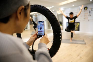 Liu Xiaojin, sets a phone as she gets ready to livestream a gym class, as the country is hit by an outbreak of the new coronavirus, in Beijing. (Reuters)