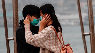 A couple wears masks as the embrace, following the outbreak of the novel coronavirus on Valentine’s Day in Hong Kong. (Reuters)