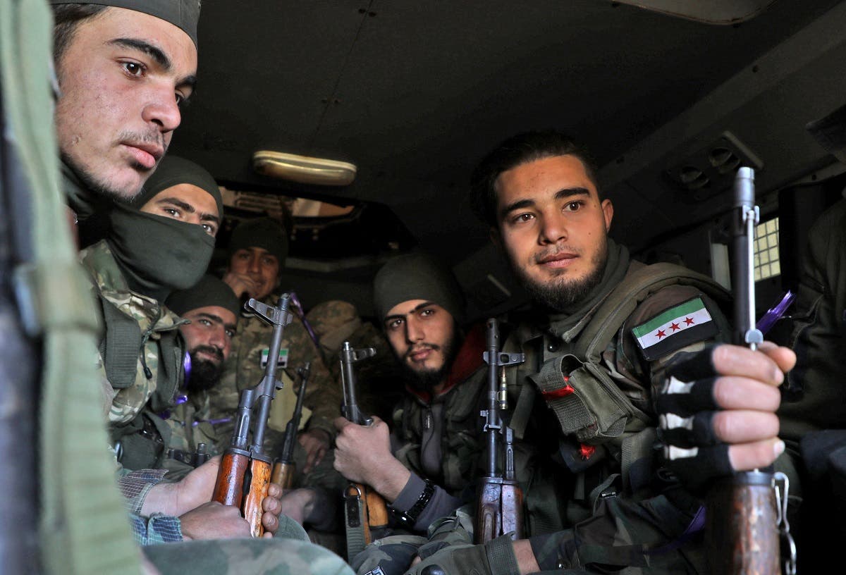 Turkish-backed Syrian fighters sit together inside a vehicle in the town of Qaminas in the southern countryside of the northwestern Idlib province on February 20, 2020, as they prepare to head into combat against government forces in nearby Nayrab to the southeast. (AFP)