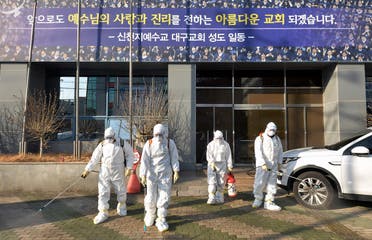 In this Wednesday, Feb. 19, 2020, photo, workers wearing protective gears spray disinfectant against the coronavirus in front of a church in Daegu, South Korea. - AP