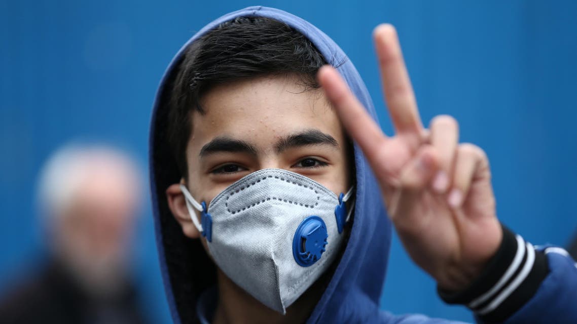 An Iranian boy gestures as he wears protective mask to prevent contracting a coronavirus in Tehran. (Reuters)
