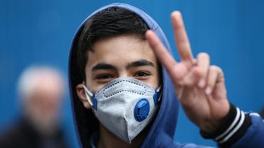 An Iranian boy gestures as he wears protective mask to prevent contracting a coronavirus in Tehran. (Reuters)