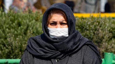 An Iranian woman wearing a protective mask and gloves, stands in a busy street in the capital Tehran on February 22, 2020. (AFP)