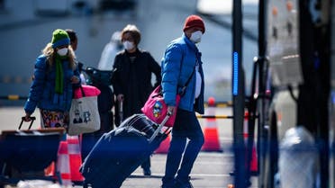Mask-clad passengers prepare to board a bus after disembarking from the Diamond Princess cruise ship, in quarantine due to fears of new COVID-19 coronavirus, at Daikoku pier cruise terminal in Yokohama on February 21, 2020. (AFP)