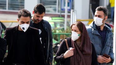 Iranians, some wearing protective masks, wait to cross a street in the capital Tehran on February 22, 2020. (AFP)