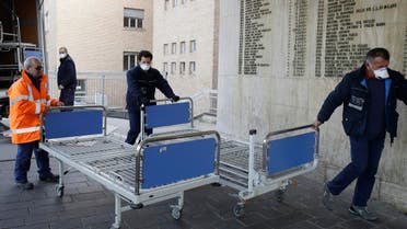 Personnel carry new beds inside a hospital of Codogno, near Lodi in Northern Italy, on Feb. 21, 2020. (AP)