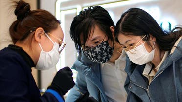A couple shop for a necklace wearing facemasks in Shanghai, China, as the coronavirus continues to spread throughout the country. (File photo: Reuters)