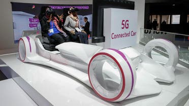 Women sit in a 5G connected car simulator displayed at the Saudi Telecom Company stand during the Mobile World Congress in Barcelona, Spain, February 27, 2018. (Reuters)