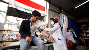 Hannaa Jassem, 24, an Iraqi nurse checks the blood pressure of young man in Baghdad, Iraq December 17, 2019. (Reuters)
