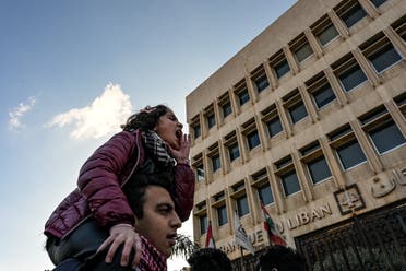 A young girl leads a chant at a protest in front of Tripoli's central bank. (Finbar Anderson)
