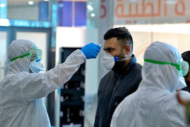 In this Friday, Feb. 21, 2020, file photo, medical staff check passengers arriving from Iran in the airport in Najaf, Iraq. Coronavirus-infected travelers from Iran already have been discovered in Lebanon and Canada. (AP Photo/Anmar Khalil, File)