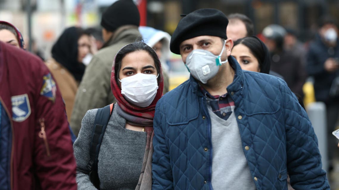Iranian couple wearing protective masks to prevent contracting a coronavirus walk at Grand Bazaar in Tehran, Iran February 20, 2020. WANA (West Asia News Agency)/Nazanin Tabatabaee via REUTERS