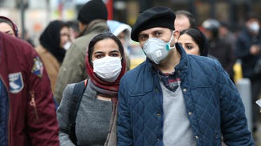 Iranian couple wearing protective masks to prevent contracting a coronavirus walk at Grand Bazaar in Tehran, Iran February 20, 2020. WANA (West Asia News Agency)/Nazanin Tabatabaee via REUTERS 