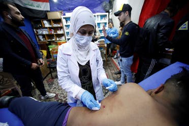 Hannaa Jassem, 24, an Iraqi nurse helps a wounded man in Baghdad, Iraq January 12, 2020. (Reuters)