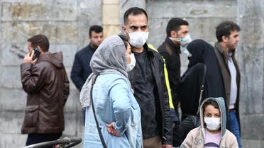 Iranian family wear protective masks to prevent contracting a coronavirus, as they stand at Grand Bazaar in Tehran, Iran. (Reuters)