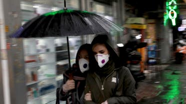 Pedestrians wear masks and gloves to help guard against the coronavirus in downtown Tehran on Feb. 25, 2020. (AP)