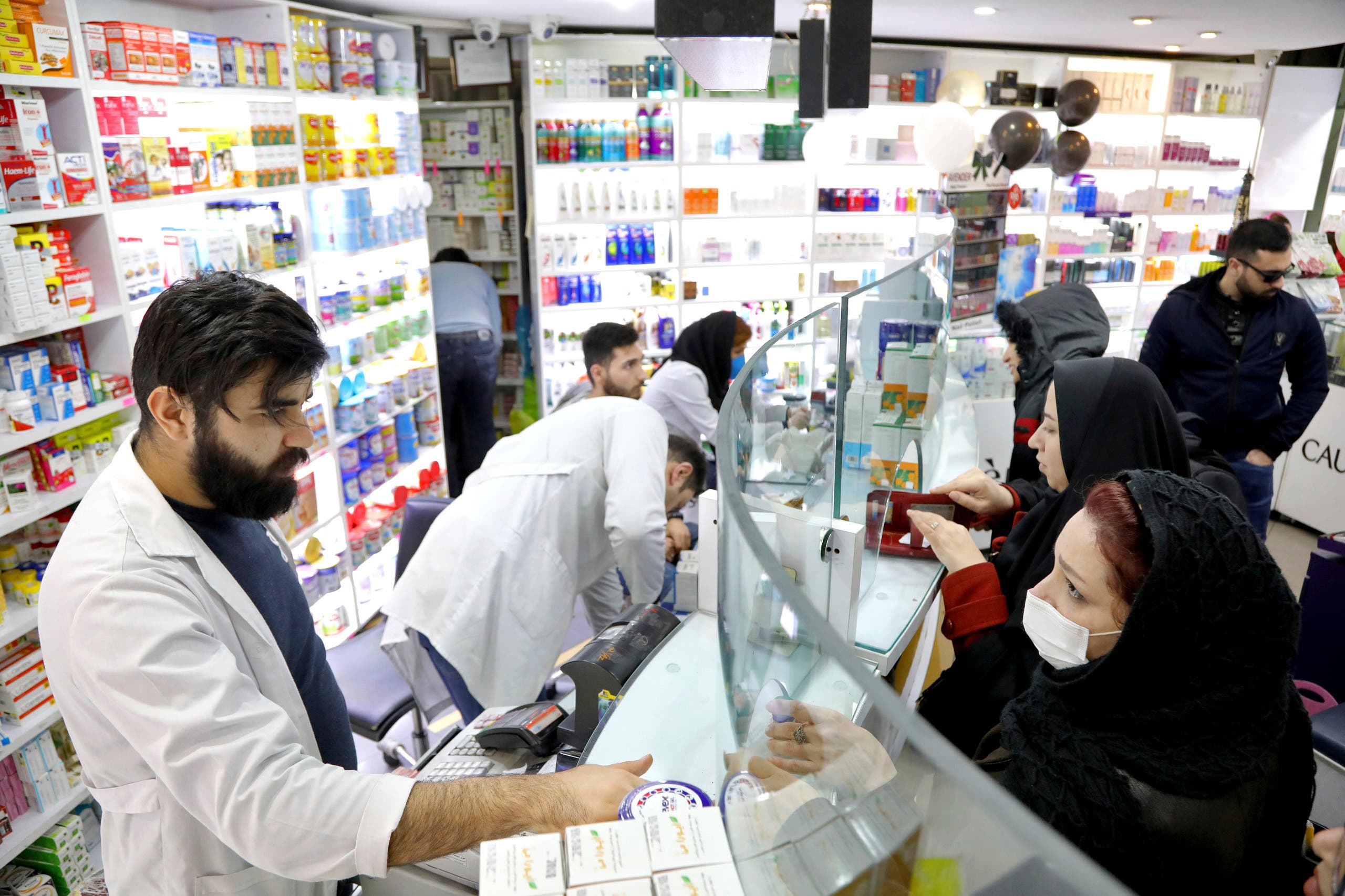 Pharmacists talk with customers at a drugstore in downtown Tehran on Feb. 25, 2020. (AP)