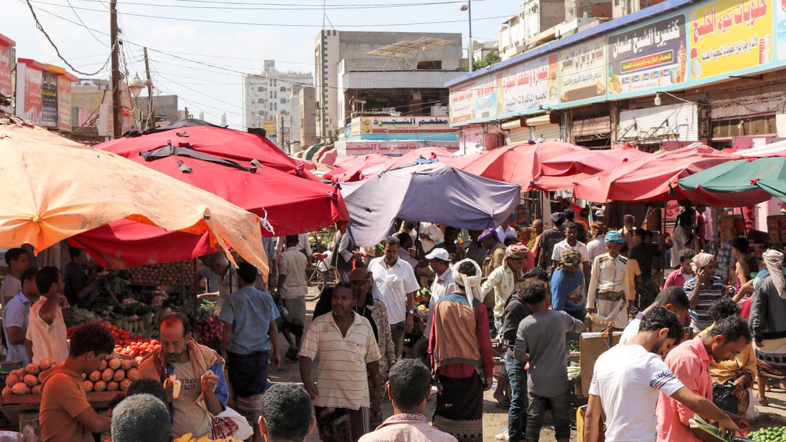People browse for produce from stalls at a market in the district of Sheikh Othman in Yemen's southern port city of Aden on January 17, 2020.
