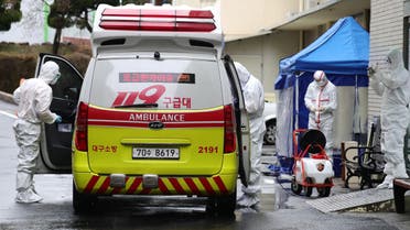 A medical worker sprays disinfectant into an ambulance at a hospital where patients infected with the coronavirus are being treated, in the southeastern city of Daegu, South Korea, on February 25, 2020. (AFP)