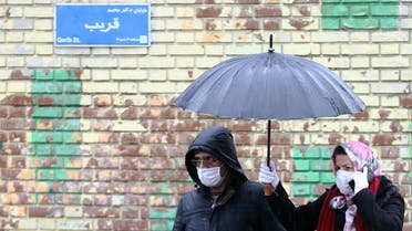 Iranian people wear protective masks to prevent contracting coronavirus, as they walk in the street in Tehran, Iran. (Reteurs)