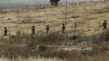 Turkish soldiers walk at the Atmeh crossing on the Syrian-Turkish border, as seen from the Syrian side, in Idlib governorate. (Reuters)