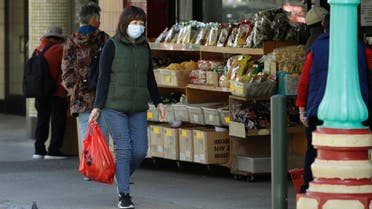 A masked shopper walks in the Chinatown district of San Francisco on Friday, January 31, 2020. 