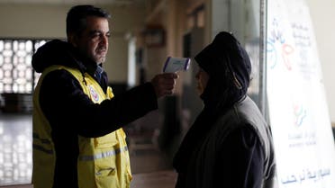 A border official checks the temperature of a passenger as a precautionary measure, following the outbreak of the coronavirus in China, at a border crossing between Syria and Lebanon in Jdaydet Yabous. (Reuters)