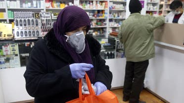 An Iranian woman wears a protective mask to prevent contracting coronavirus, as she is seen at a drug store in Tehran. (Reuters)