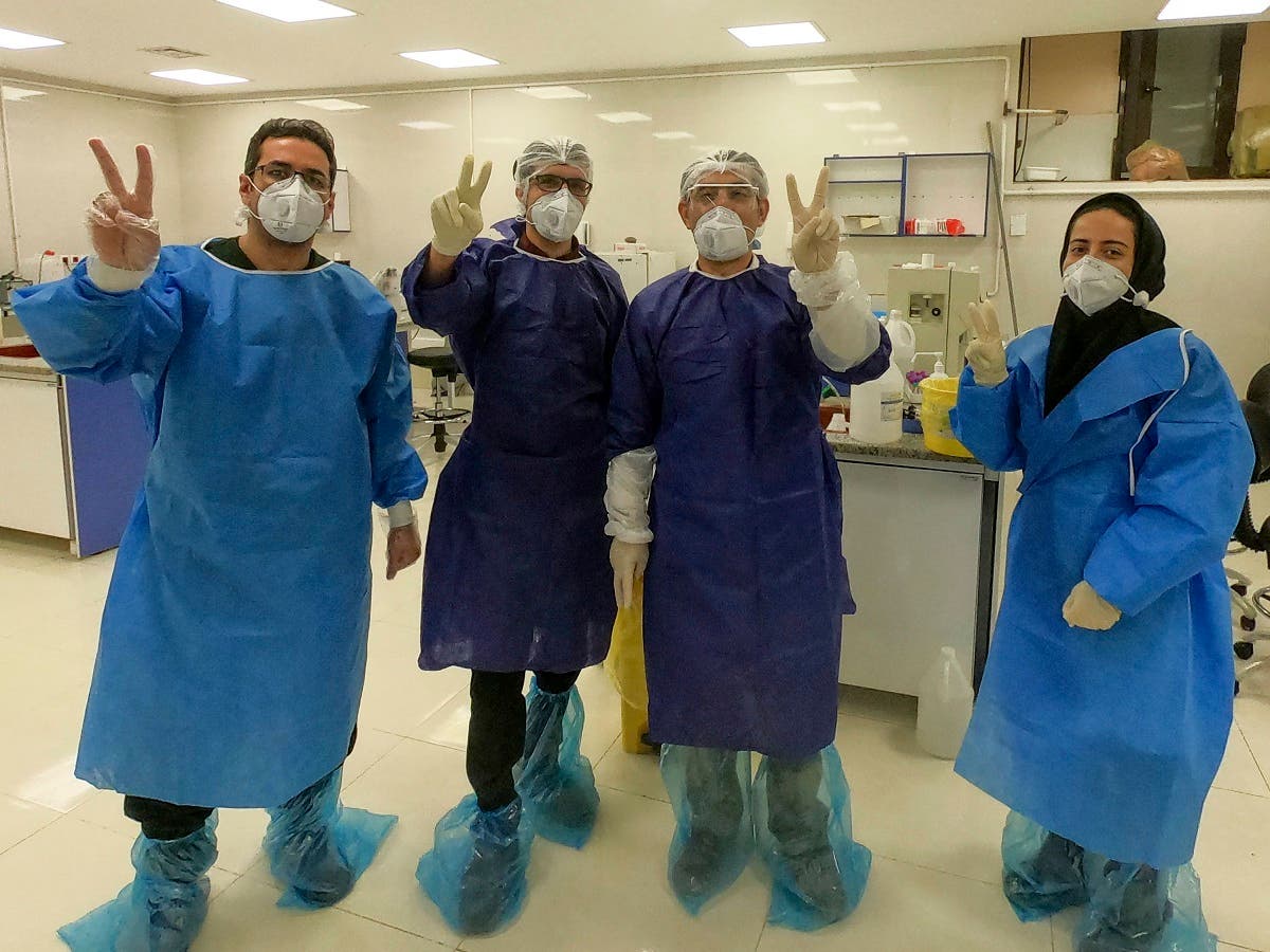 Medics flash the victory sign in a ward dedicated for people infected with the coronavirus, at Forqani Hospital in Qom, 78 miles (125 kilometers) south of the capital Tehran, Iran, Wednesday, Feb. 26, 2020. (AP)