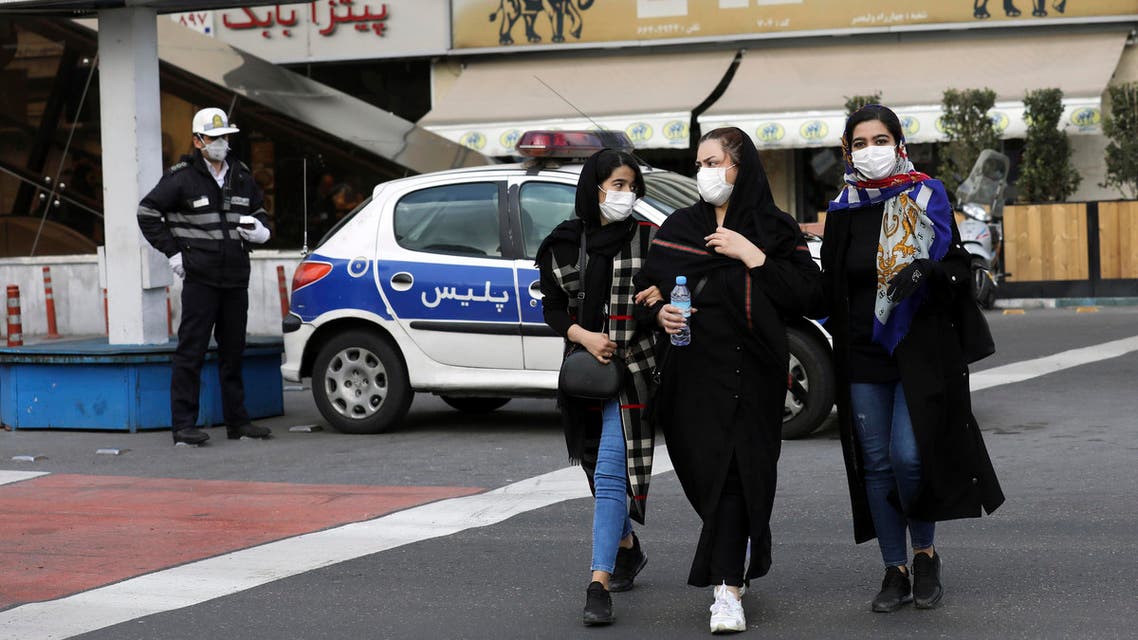 A policeman and pedestrians wear masks to help guard against the Coronavirus, in downtown Tehran. (Reuters)