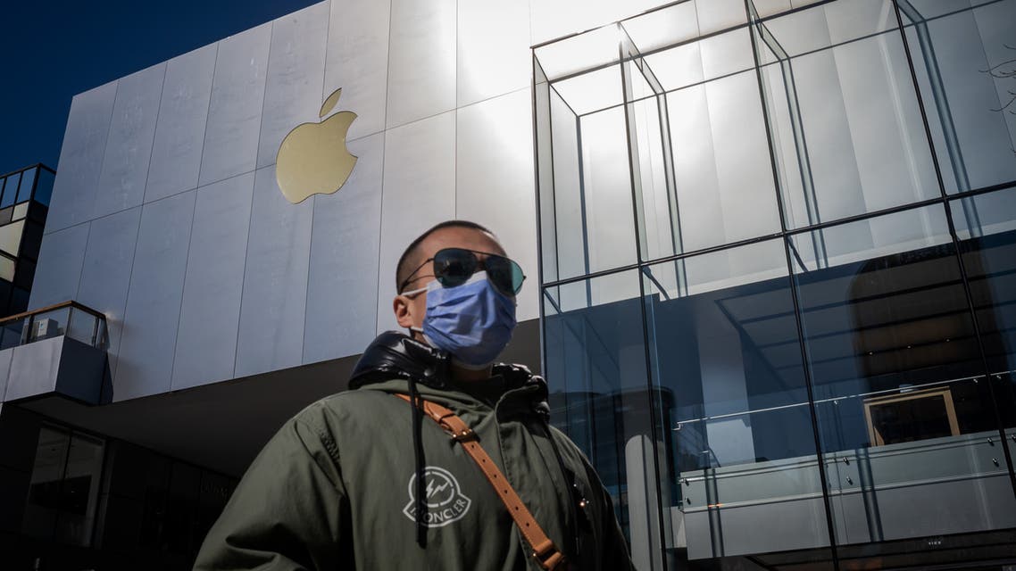 A man wearing a facemask to protect against the COVID-19 coronavirus walks outside an Apple Store in Beijing on February 22, 2020. The US tech giant said in a statement February 18 its revenue for the current quarter would be below its forecasts, and that worldwide iPhone supply will be temporarily constrained because of the global virus outbreak, notably in China where Apple manufactures most of its devices.