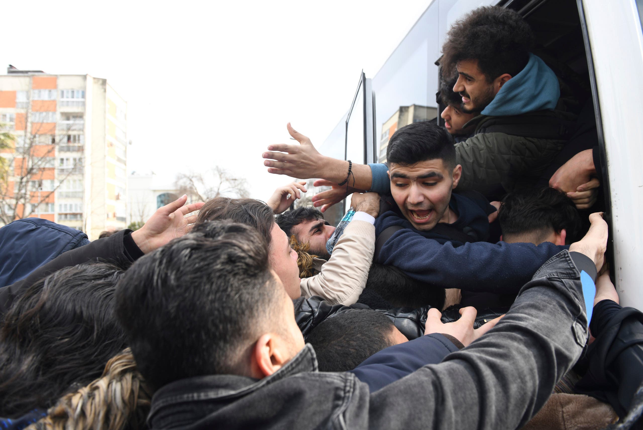 Migrants struggle to board a bus to go to the Greek border, in Istanbul on Feb. 28, 2020. (AP)