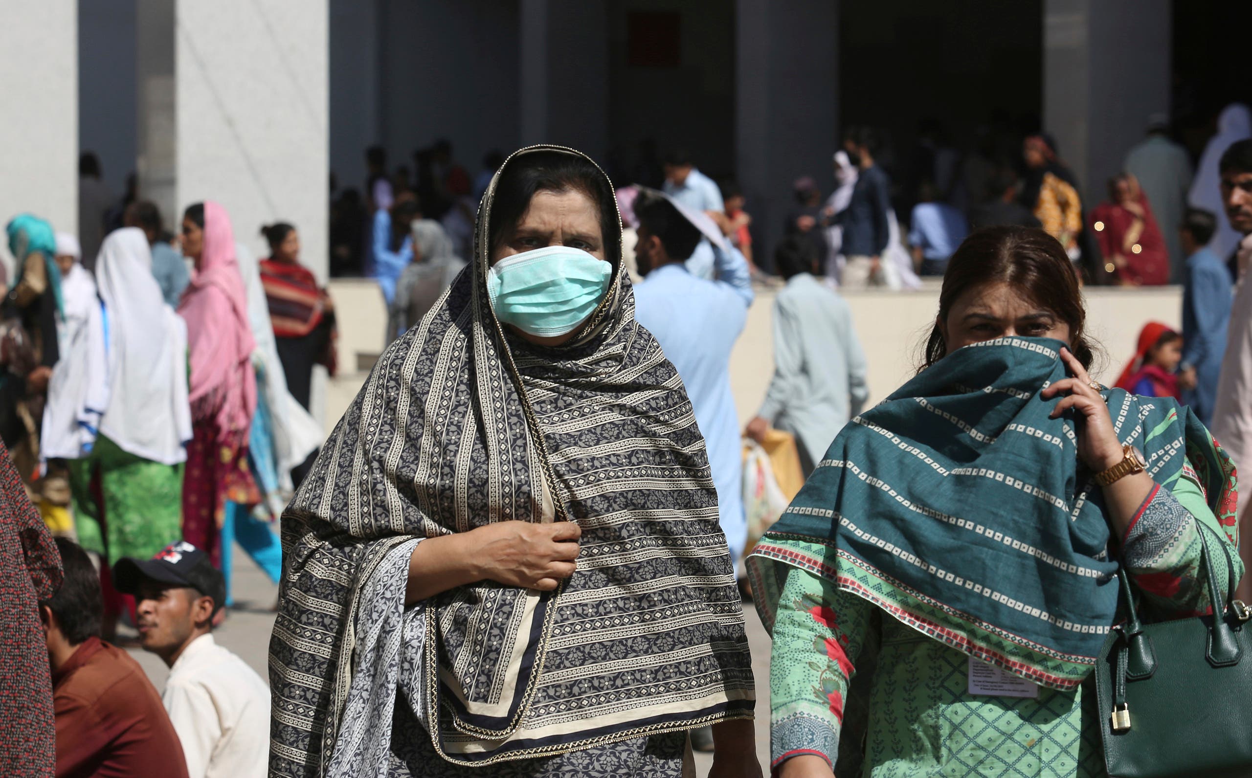 Pakistani women wearing face masks leave the Aga Khan hospital where a patient suspected of having contracted coronavirus was admitted, in Karachi. (AP)