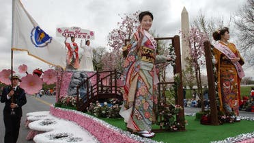 The 2004 Cherry Blossom Queens from Japan wave as they pass the Washington Monument in Washington, Saturday, April 3, 2004. (AP)