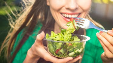 Woman eating healthy salad stock photo