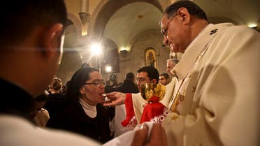 A nun takes communion from Latin Patriarch of Jerusalem Fuad Twal (R) during the midnight mass ceremony which marks the beginning of Christmas Day at the Church of the Nativity in the West Bank town of Bethlehem on December 25, 2010. (AFP)