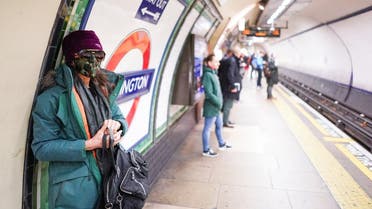 A woman wearing a protective face mask stands on a London Underground platform in central London. (Reuters)