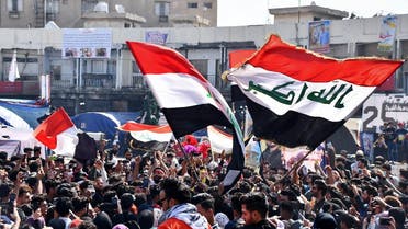 Student protesters, some wearing protective face masks, march with Iraqi national flags during an anti-government demonstration in Iraq's southern city of Nasiriyah in Dhi Qar province on March 1, 2020. (AFP)