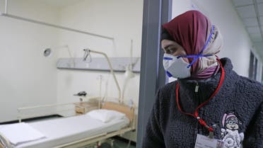 A Lebanese employee wearing a protective mask looks at a bed in a ward where the first case of coronavirus in the country is being treated, at the Rafik Hariri University Hospital on February 22, 2020. (AFP)