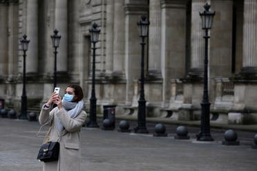 A tourist wearing a mask makes a selfie outside the Louvre museum Friday, February 28, 2020 in Paris. (AP)
