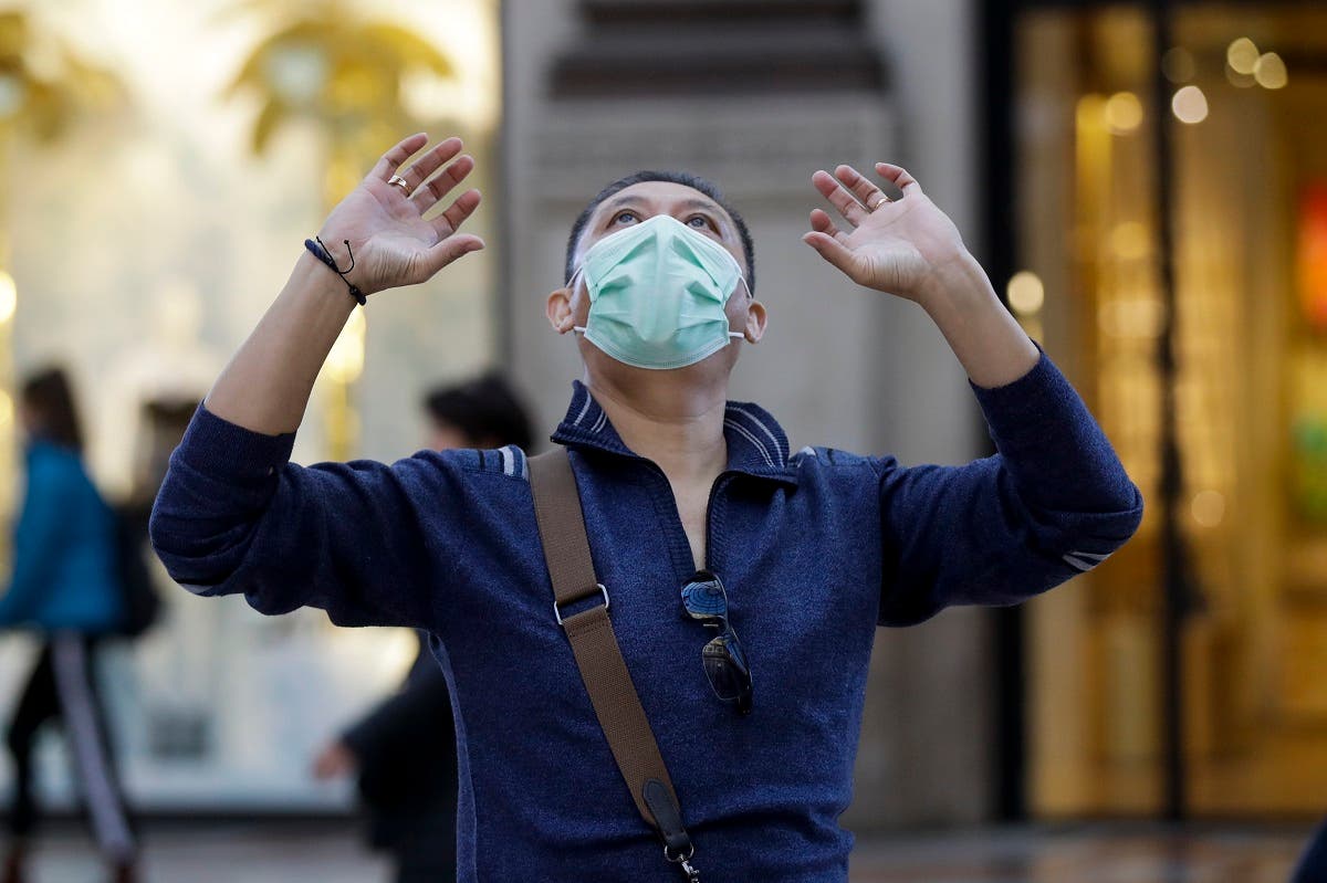 A man wearing a protective mask looks up as he walks along the Vittorio Emanuele Gallery shopping arcade, in Milan, Italy, Friday, February 28, 2020. (Photo: AP)