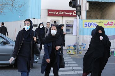 Women wearing protective masks cross a street in the Iranian capital Tehran on March 2, 2020, following the coronavirus outbreak. (AFP)